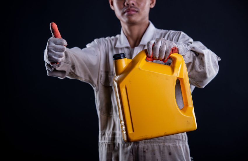 Car mechanic wearing a white uniform stand holding wrench isolated on gray background with copy space.