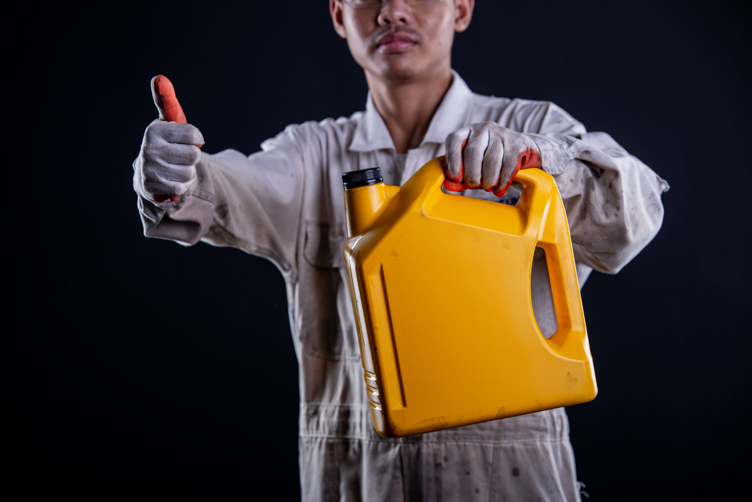 Car mechanic wearing a white uniform stand holding wrench isolated on gray background with copy space.